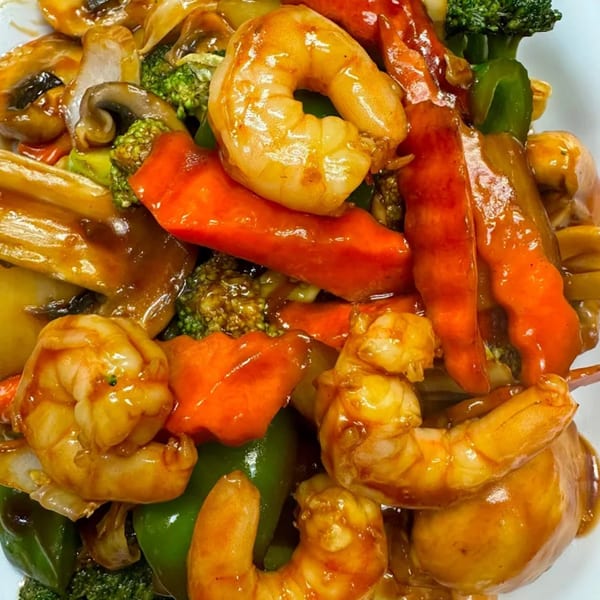 Close-up of Chinese shrimp stir-fry with broccoli, mushrooms, and bell peppers in a savory sauce.